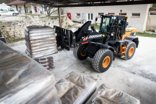 Kolový nakladač Doosan DL220-7 převáží paletu ve skladu