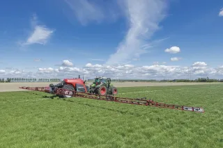 Tažený postřikovač Kverneland iXtrack T4 s rozloženým ramenem na poli