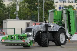 Maskovaný autonomní traktor Belarus s žacími stroji