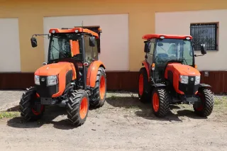 Dva oranžové kompaktní traktory Kubota