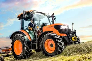 Traktor Kubota při obracení sena