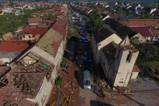 Pohled na domy s poničenými střechami po tornádu