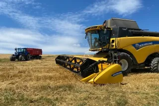 Sklízecí mlátička New Holland a traktor s návěsem na poli