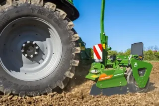 Detail rotačních bran Amazone u kola traktoru na poli