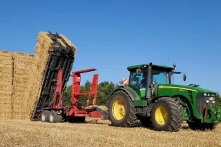 Traktor s přepravníkem Anderson StackPro skládá hranaté balíky slámy