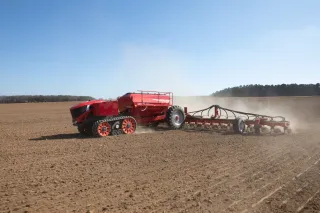 Červený autonomní secí stroj Horsch při práci na poli