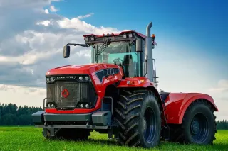 Červený traktor Kirovec na poli