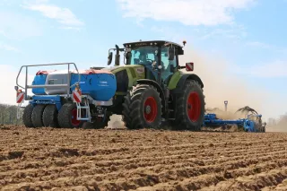 Traktor CLAAS s čelním zásobníkem Lemken při setí na poli