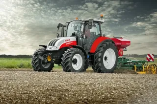 Traktor Steyr Multi s připojeným strojem na poli