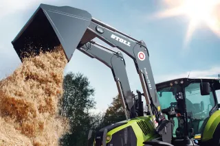 Čelní nakladač Stoll na traktoru vysypává sypký materiál