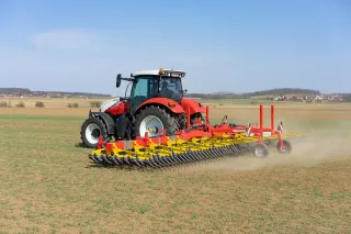 Traktor Steyr s prutovými branami Pöttinger na poli