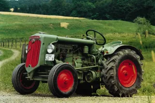 Historický zelený traktor Hürlimann na louce