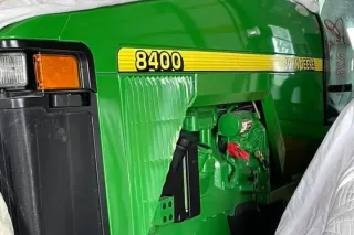 Detail zeleného traktoru John Deere 8400 v hale