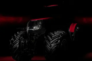 Přední část traktoru Case IH osvětlená na tmavém pozadí