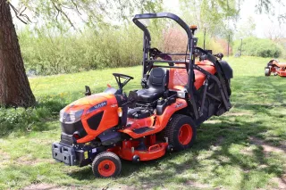 Oranžový travní traktor Kubota s ochranným rámem na trávníku