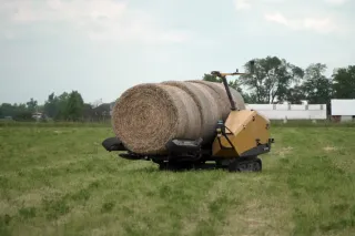 Autonomní stroj Vermeer převážející kulatý balík na louce