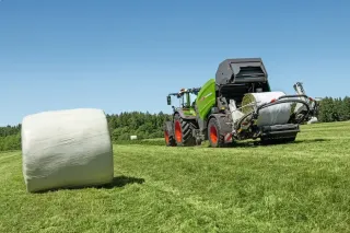 Lis Fendt Rotana a zabalený kulatý balík na louce