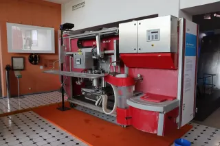 Červenobílý dojicí robot Lely Astronaut vystavený v muzeu