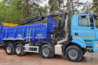 Modrý nákladní vůz Tatra Phoenix s nástavbou ZDT a hydraulickou rukou.