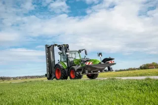 Traktor Fendt s žacím strojem na travnatém poli