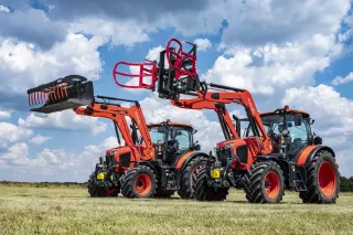 Dva oranžové traktory Kubota s různým příslušenstvím čelních nakladačů.