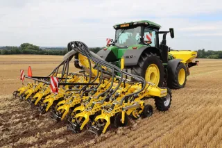 Traktor s řádkovým kypřičem Bednar Strip-Master na strništi.