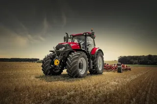 Červený traktor Case IH s nářadím na poli
