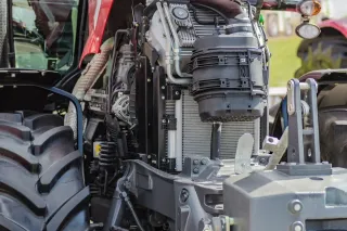 Detail motoru a podvozku traktoru.