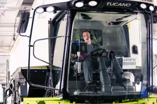 Pracovník u kabiny sklízecí mlátičky Claas Tucano ve výrobním závodu.