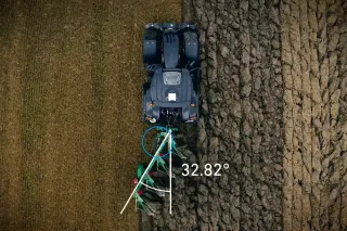 Letecký pohled na traktor s pluhem a vyznačeným úhlem tahové linie.
