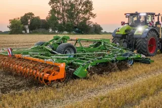 Traktor s radličkovým podmítačem AMAZONE Cobra na strništi.