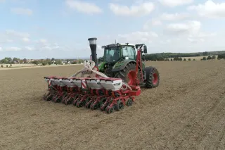 Traktor se secím strojem Kverneland Optima F na poli.
