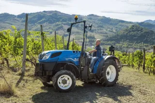 Modrý speciální traktor New Holland T4 ve vinici.