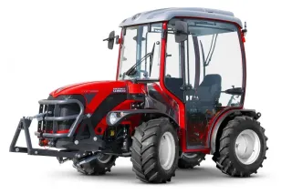 Červený malý traktor Antonio Carraro s kabinou na bílém pozadí.