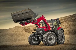 Červený traktor Case IH s čelním nakladačem a zvednutou lopatou.