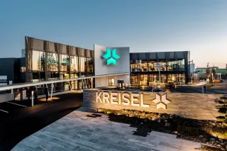 Budova centrály Kreisel Electric s logem společnosti za soumraku.
