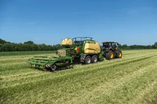 Lis Krone Big Pack za traktorem při sklizni sena.