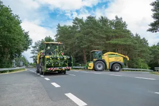 Dvě sklízecí řezačky Krone na silnici při přepravě.
