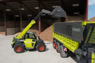 Teleskopický manipulátor Claas Scorpion nakládá materiál do vozu Claas.