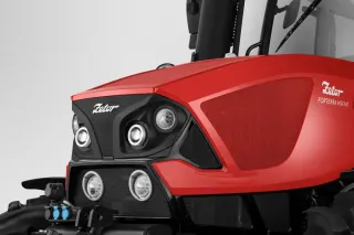 Detail nové červené čelní masky traktoru Zetor Forterra se světlomety.