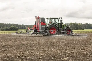 Traktor s neseným postřikovačem Horsch Leeb CS na poli