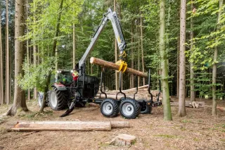 Lesní vyvážecí návěs Trejon Multiforest s nakládacím ramenem při práci v lese