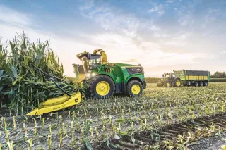 Zelená samojízdná řezačka John Deere 9000 při sklizni kukuřice