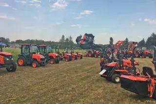 Řada oranžových strojů Kubota na předváděcí akci