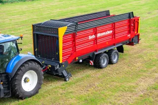Traktor táhnoucí červený sběrací vůz Schuitemaker Rapide 85