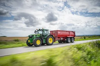 Zelený traktor John Deere 6R 185 na poli