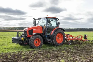 Oranžový traktor Kubota M6001 Utility na louce