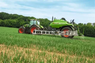 Traktor Fendt s taženým postřikovačem na poli