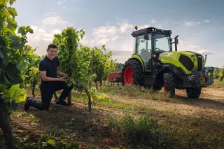 Muž u úzkorozchodného traktoru CLAAS NEXOS ve vinici