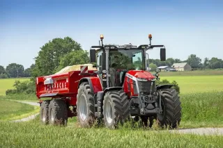 Traktor Massey Ferguson 8S s červeným návěsem na cestě